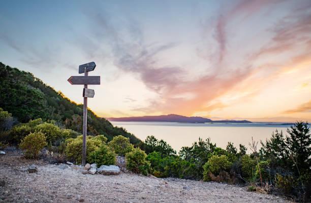 Rural scenic landscape with crossroads on the hill during a beautiful sunset. Two different directions. Concept of choosing the correct way. Left and right path, two way, different directions.