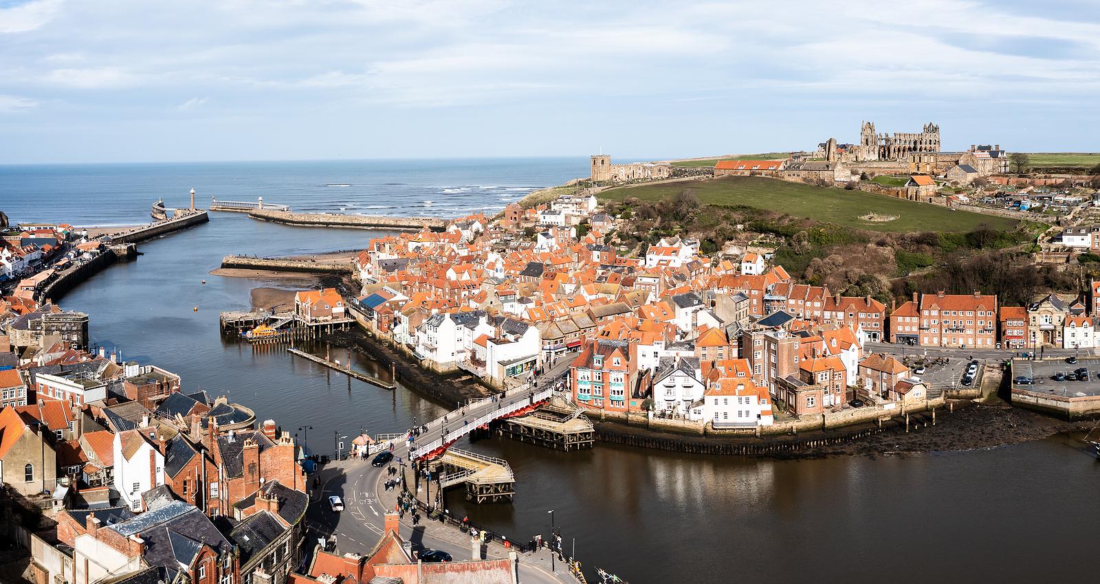 WHITBY, UK - MARCH 12, 2023. An aerial landscape of the harbour and seaside town of Whitby in North Yorkshire with Whitby Abbey prominent